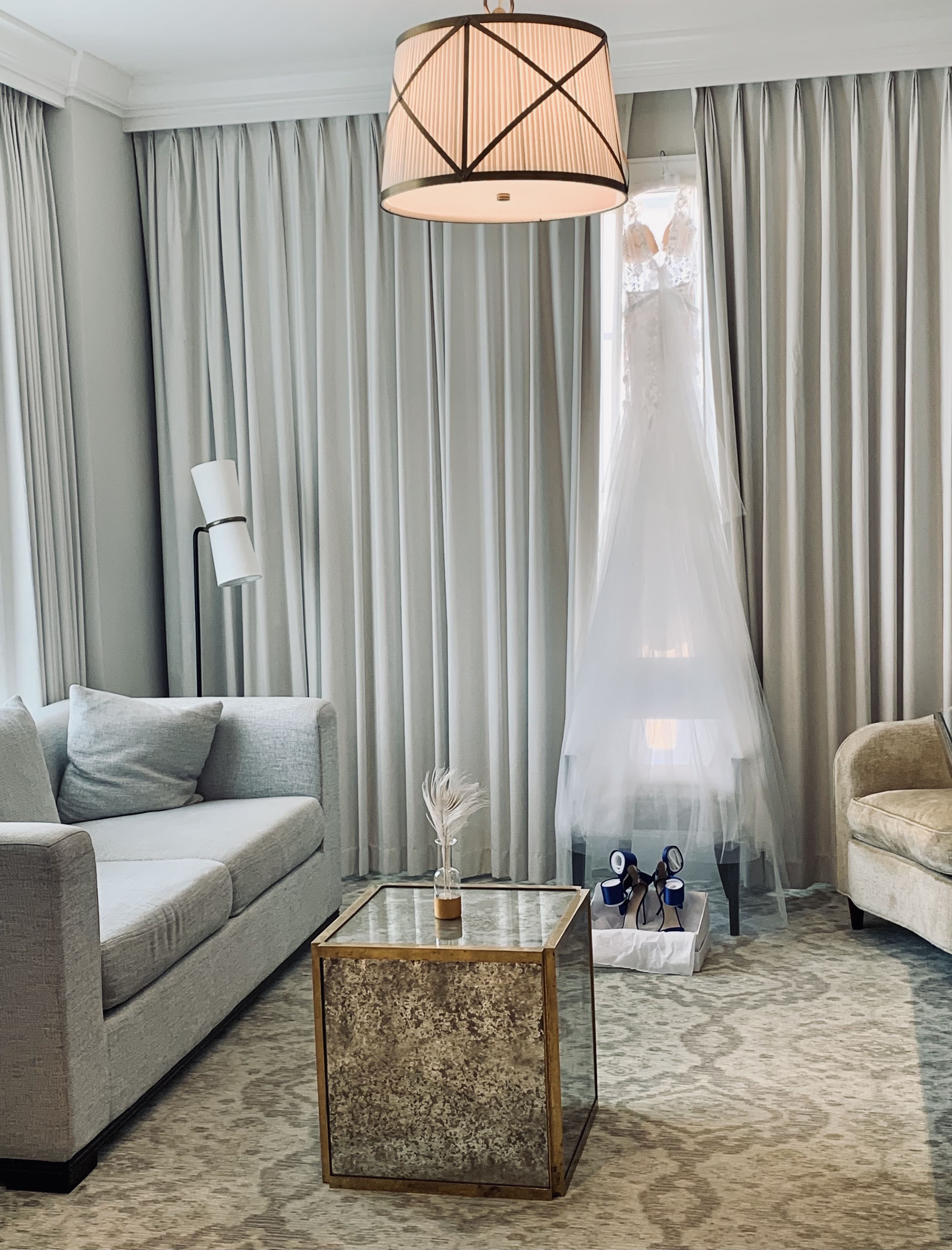 Bridal dressing suite with a gown hanging by the window